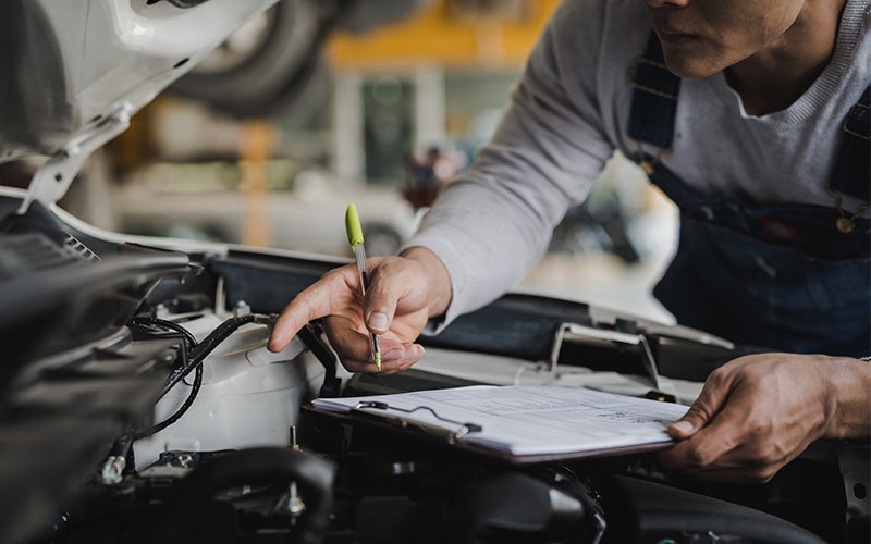 Service technician inspecting a vehicle at Sunset Chevrolet
